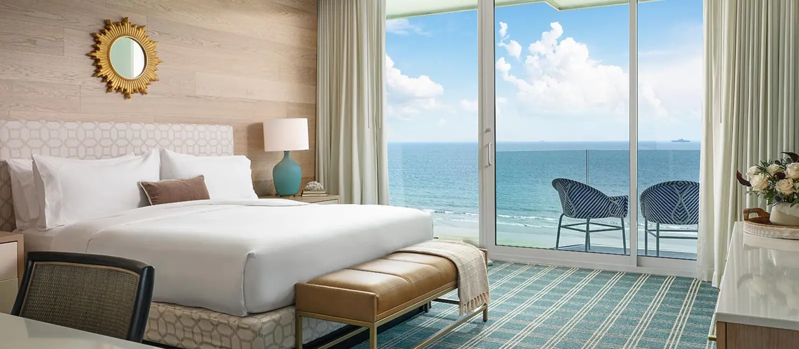 Luxury beachfront guest room at Hotel del Coronado featuring a king bed, modern décor, and a private balcony with ocean views.